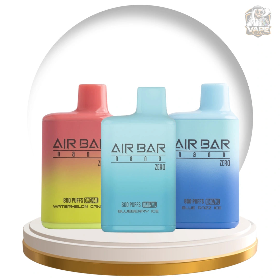 Three Air Bar Nano disposable vape devices displayed side-by-side on a gold and white circular pedestal. The center device is light blue (Blueberry Ice), flanked by a pink-to-yellow gradient device (Watermelon Candy) and a light blue-to-dark blue gradient device (Blue Razz Ice).