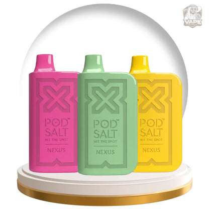 Three Pod Salt Nexus vape pods in pink, mint green, and yellow, displayed side-by-side on a white and gold circular pedestal inside a clear dome-like frame.