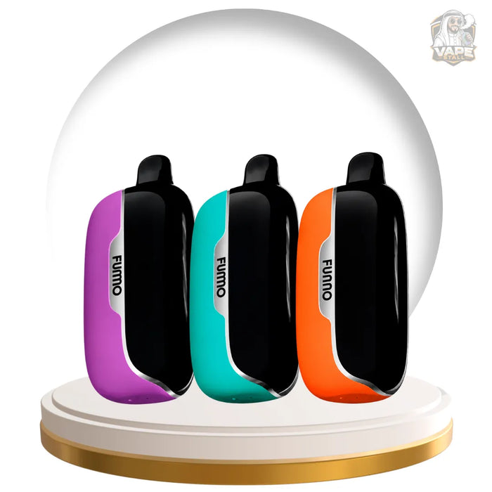 Three FUMO vape devices in purple, teal, and orange, displayed side-by-side on a white and gold circular pedestal with a white dome backdrop.
