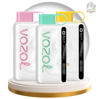 Three Vozol disposable vape devices in pink, mint green, and yellow packaging, displayed on a gold and white rotating platform against a white background with a gray dome.