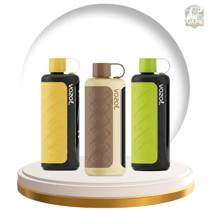 Three Voozol vape devices displayed on a white and gold rotating platform, set against a large white circular backdrop. The devices come in three colorways: yellow, beige/brown, and green, all with black side panels and white Voozol branding.